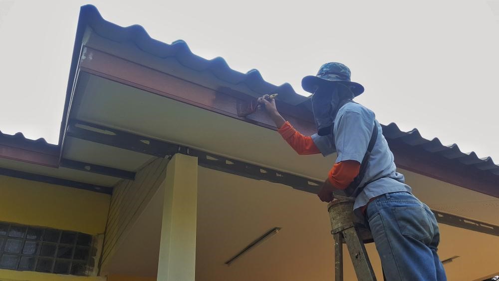 屋根を塗装する人